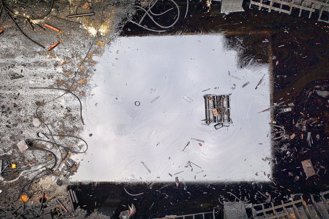 Free Top view of black reflecting dirty river contaminated with oil products and litter Stock Photo