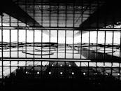 一张黑白照片，展现了现代建筑天花板的几何结构与倒影