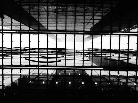 一张黑白照片，展现了现代建筑天花板的几何结构与倒影