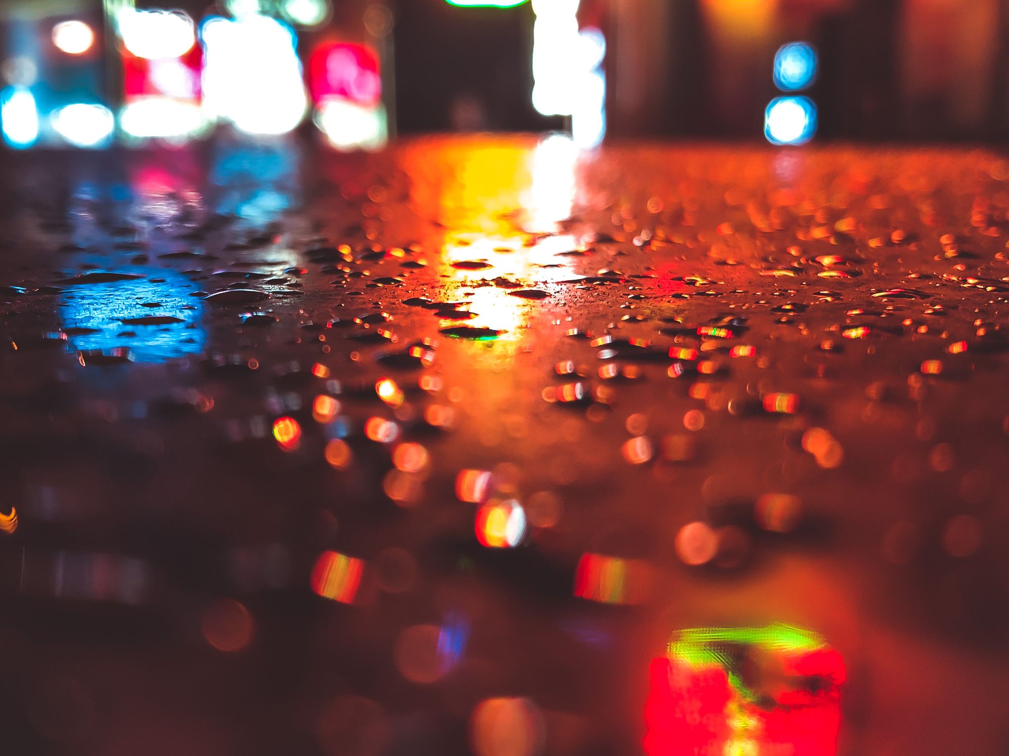 Close-up of a Wet Street Reflecting City Lights at Night · Free Stock Photo