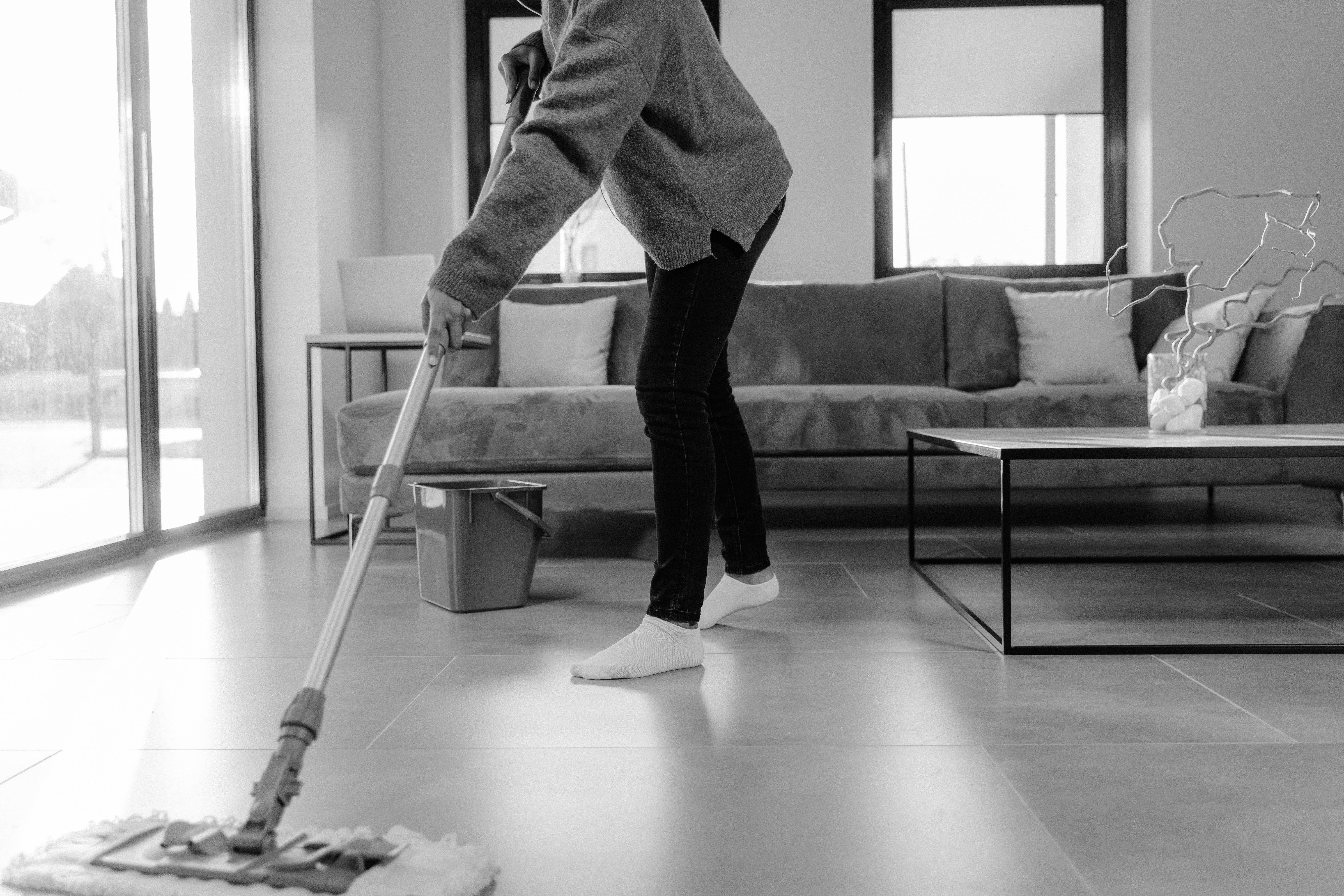 A Grayscale Photo of a Person Mopping the Floor · Free Stock Photo