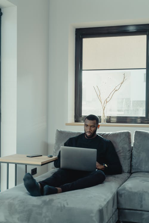 Man Working on Laptop while Sitting on the Couch