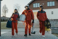 Cleaners Walking While Holding Cleaning Equipment