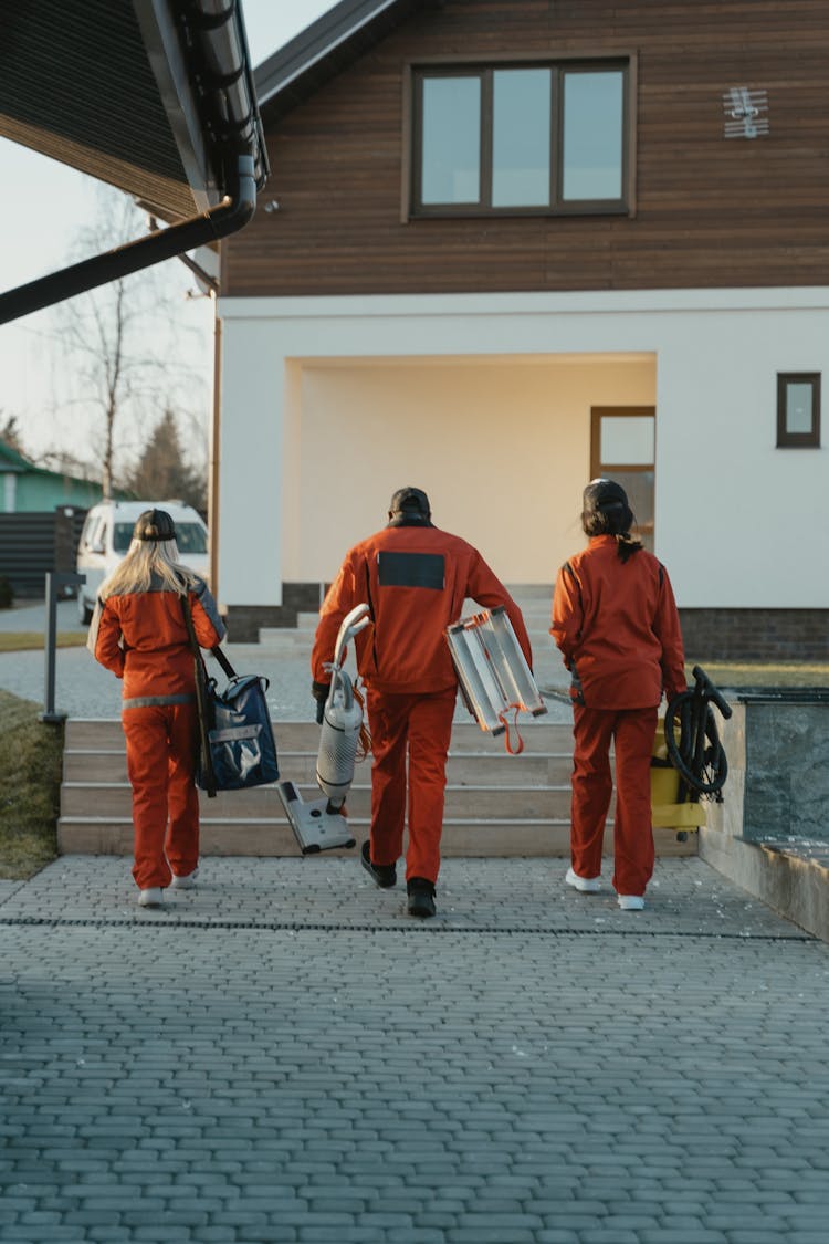 Back View Of Workers Walking Towards A House