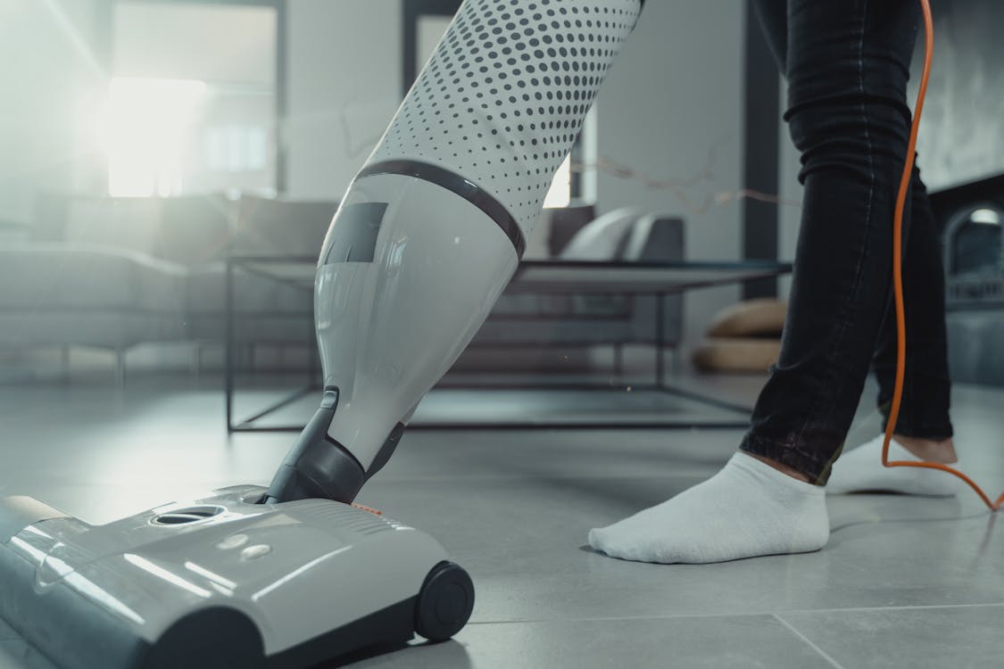 Free A Person Wearing White Socks using a Vacuum Cleaner on Tile Floor Stock Photo