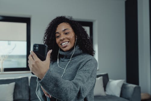 Woman in Gray Sweater Using a Smartphone