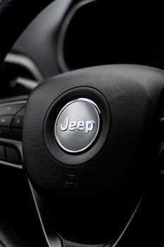 Detailed close-up of Jeep steering wheel inside a vehicle, showcasing automotive design.