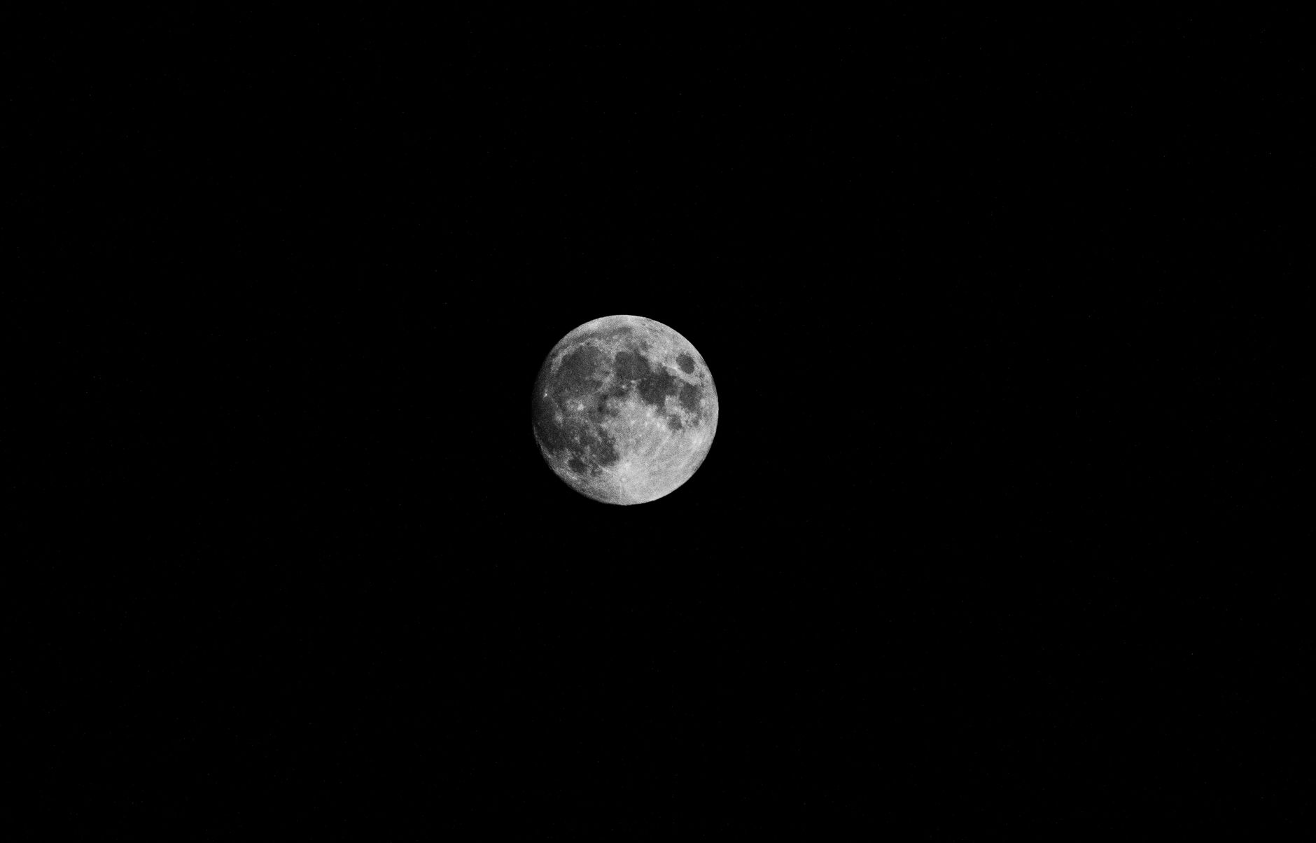 A detailed image of the full moon set against a clear, starry night sky, capturing lunar features vividly.