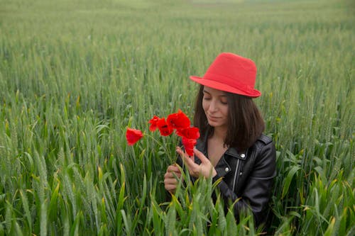 Fotobanka s bezplatnými fotkami na tému bruneta, červené kvety, červený klobúk