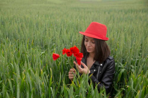 Darmowe zdjęcie z galerii z brunetka, czarna skórzana kurtka, czerwone kwiaty