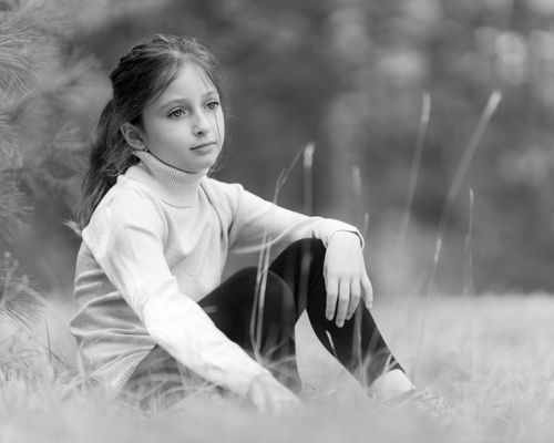 Free Black and white of adorable girl looking away on lawn with fresh grass in forest Stock Photo