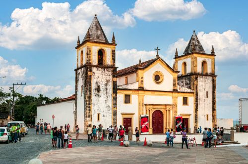Free A historic church in Olinda, Brazil, with visitors gathering outside under a blue sky. Stock Photo