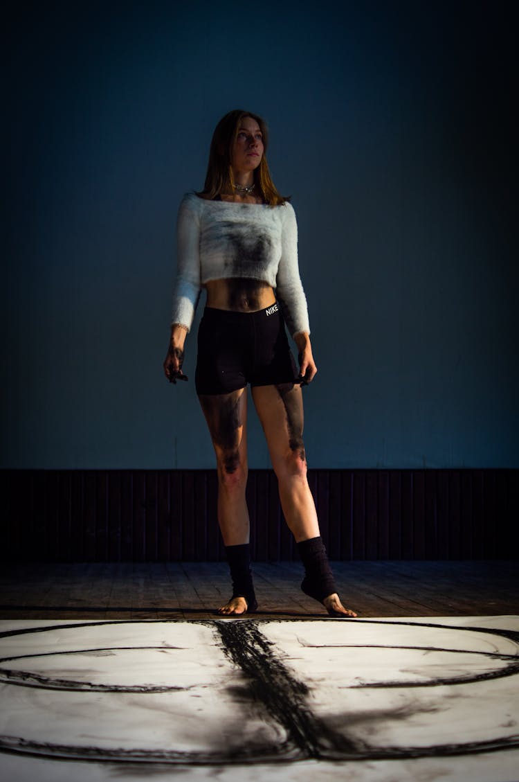 Portrait Of A Female Artist Standing In A Dark Studio