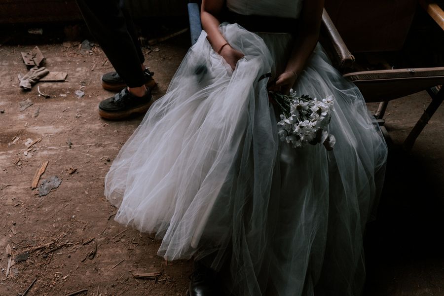 Bride in a white wedding gown holding a bouquet of white flowers