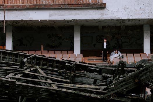 A striking wedding scene in an abandoned building with rubble and decay.