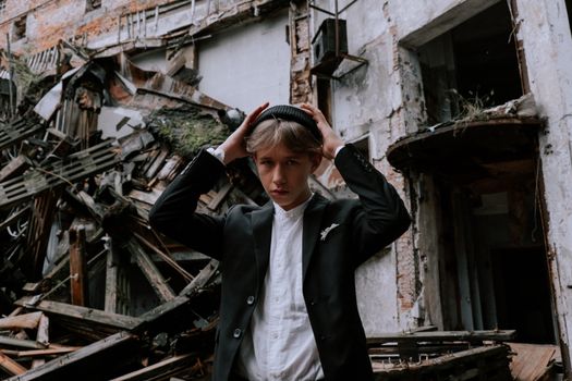 A young man poses confidently in a stylish outfit against a backdrop of urban ruins, exuding a sense of modern rebellion.