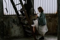 Woman in Gray Jacket and White Skirt Standing on Stairs