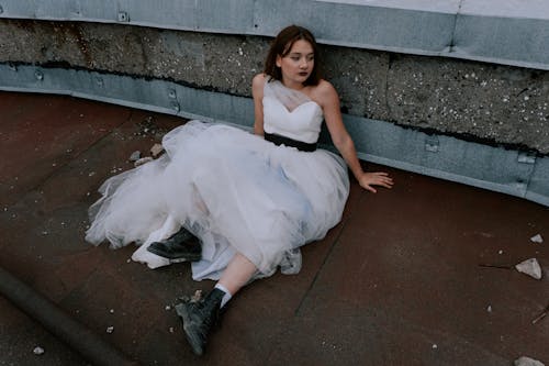 Mulher De Vestido Branco Sem Mangas Sentada Em Uma Escada De Concreto Marrom