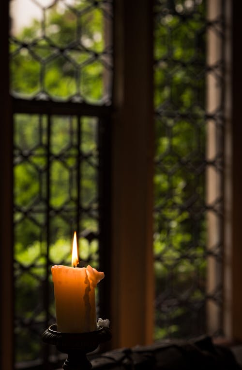 Yellow Lit Candle in Candle holder