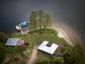 Aerial shot of a lakeside area with boats and picnic benches in Wdzydze Kiszewskie, Poland.