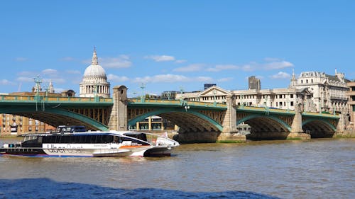 Tour Boat on a River Passing under the Bridge in a City 