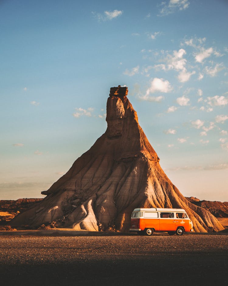 White And Orange Van Near Brown Rock Formation