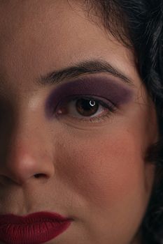 Intimate close-up highlighting bold eye makeup and red lips for a striking look.