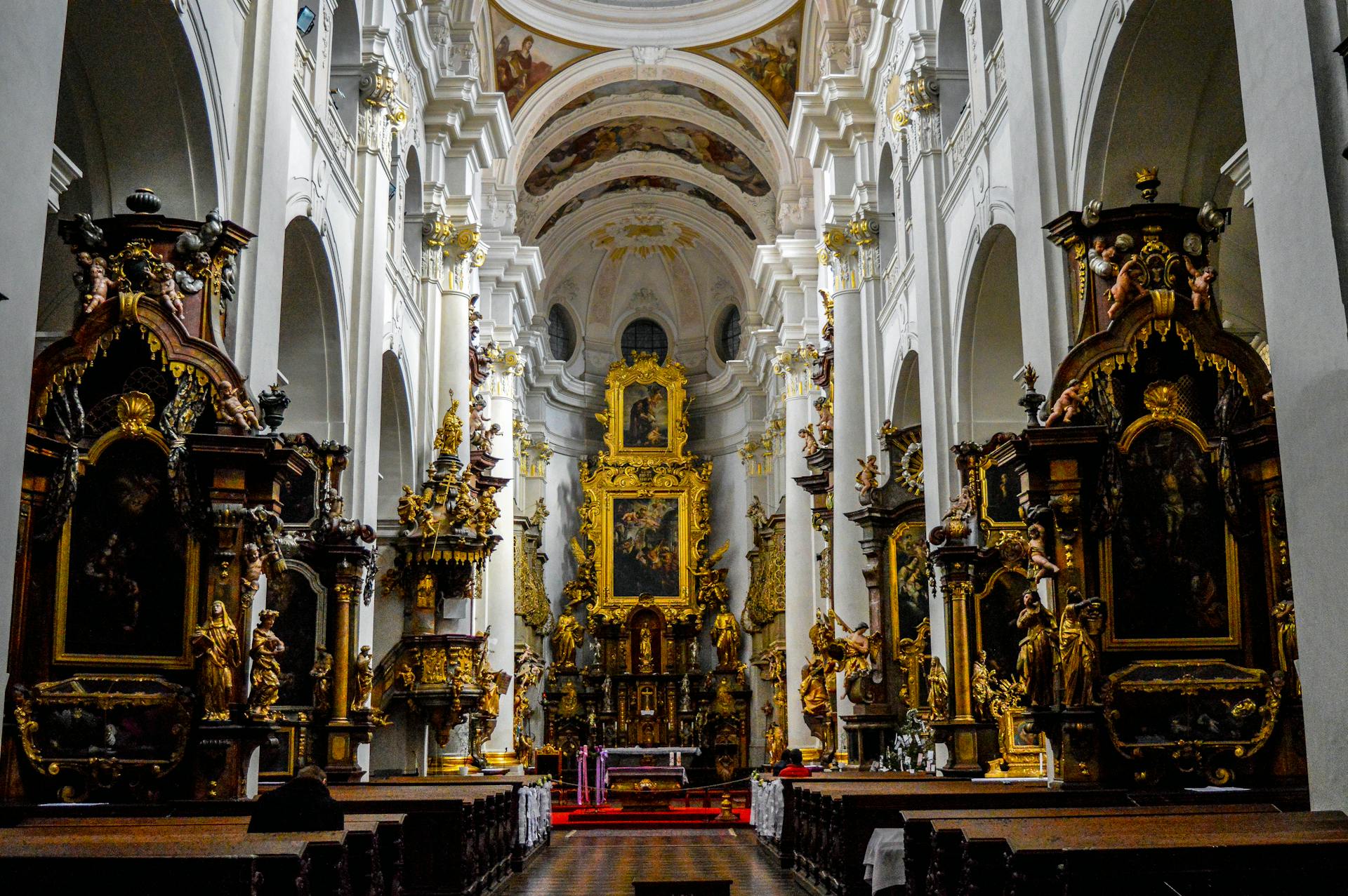 Explore the stunning Gothic interior of St. Thomas Church in Prague, featuring intricate altars and murals.