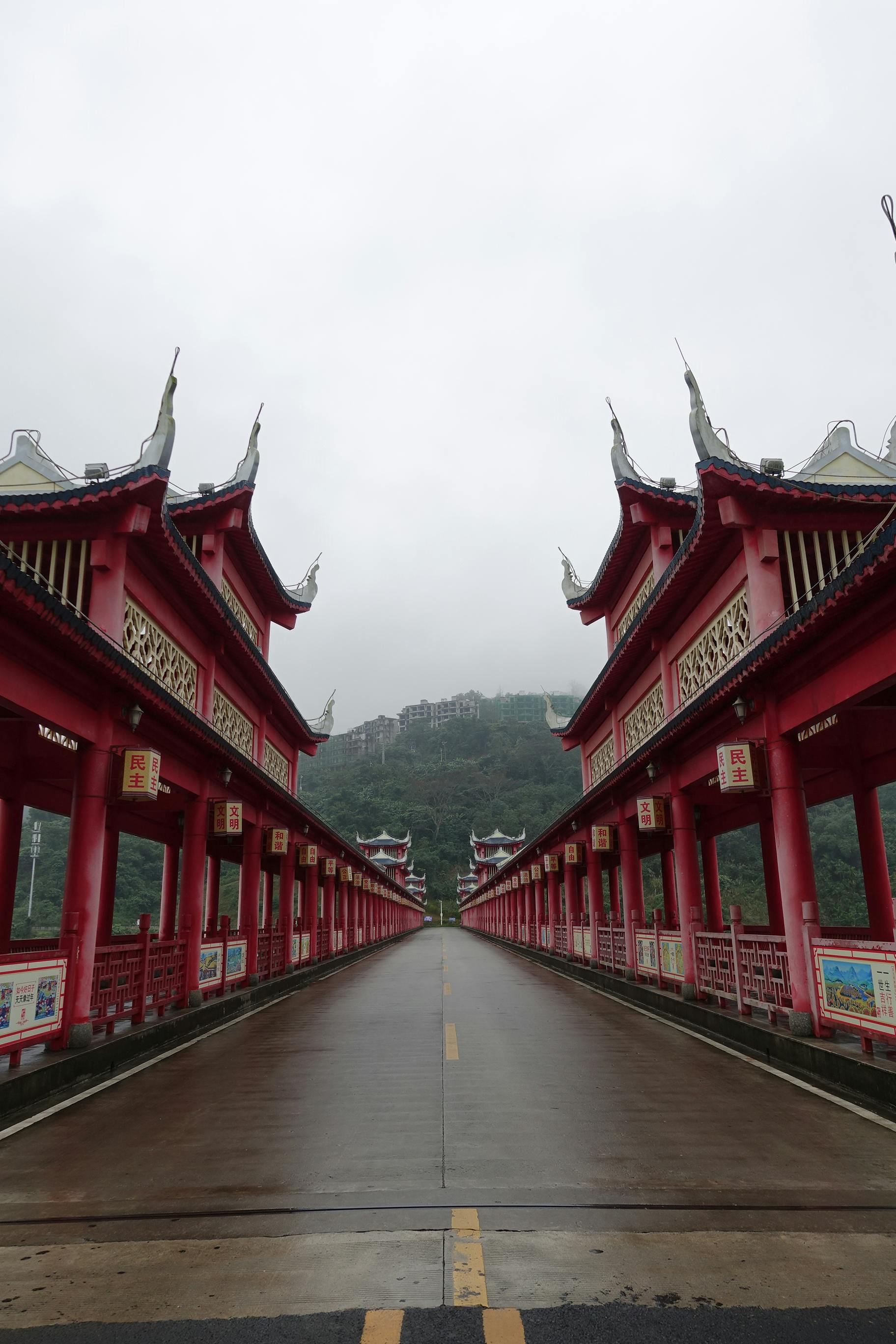 empty road between asian walkways under red wooden roofs