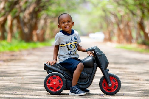 Free Boy Sitting on a Toy Scooter Stock Photo