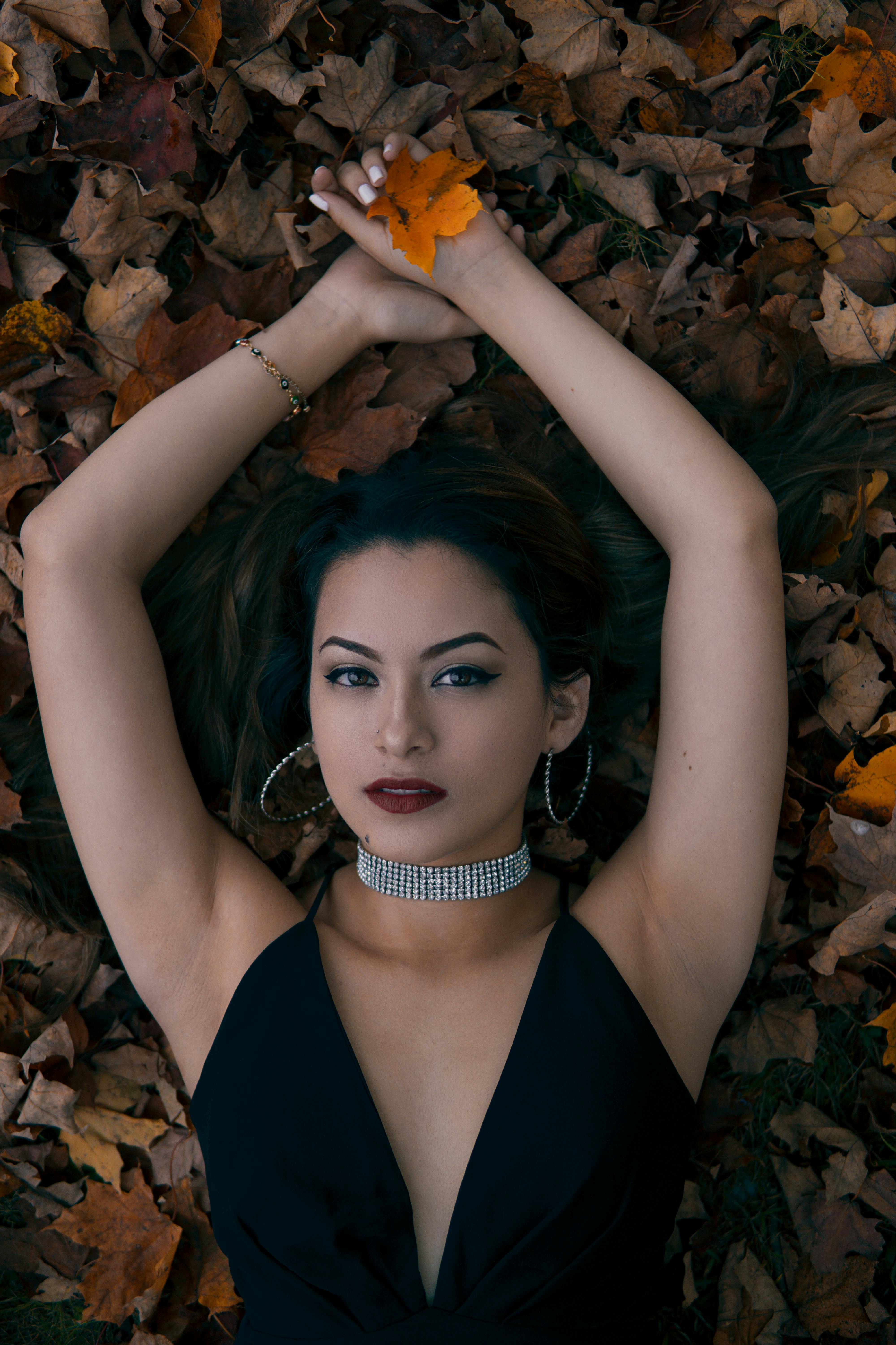 woman lying opening arms holding leaf