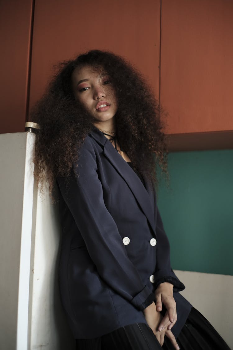 Elegant Ethnic Lady In Suit Leaning On Fridge