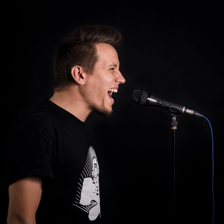 Man in Black T-shirt Singing Near Microphone