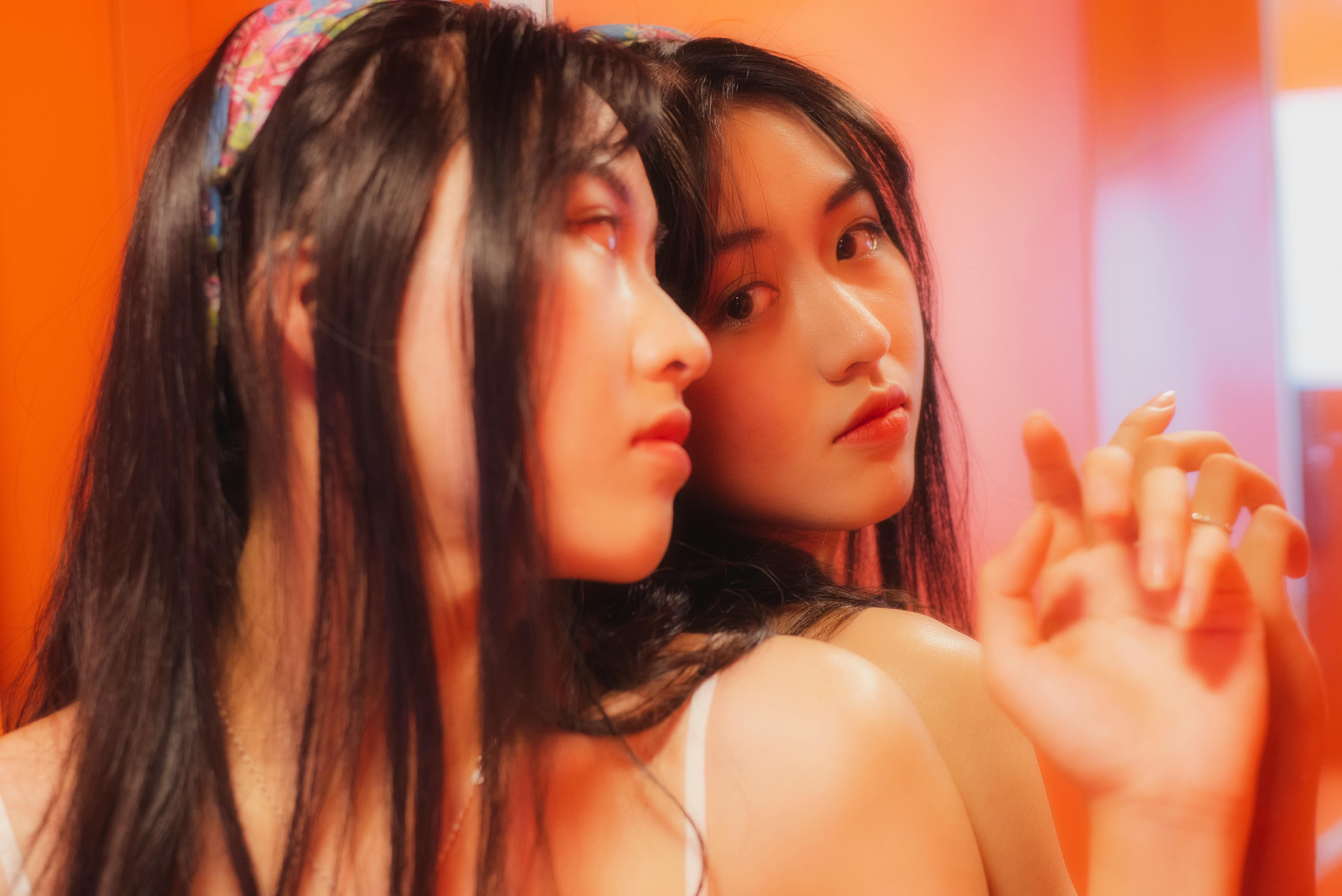 Close-up portrait of a teenage girl looking at her reflection in the mirror with a warm ambiance.