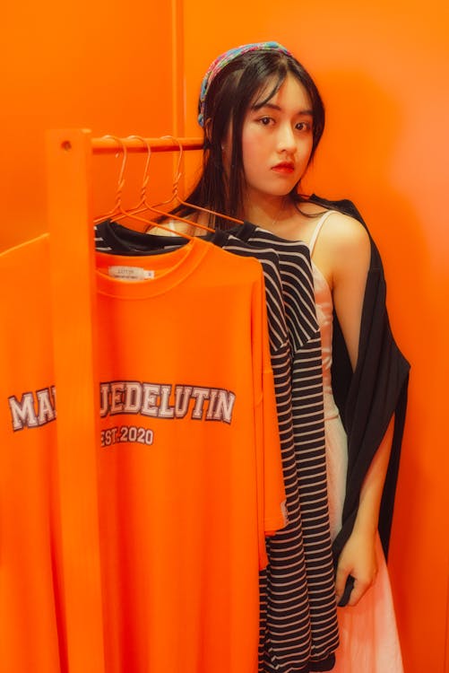 Beautiful Girl Standing Beside Clothing Rack