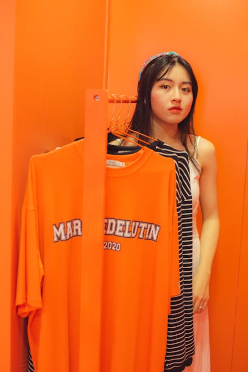 Teenage Girl Standing Beside Clothing Rack
