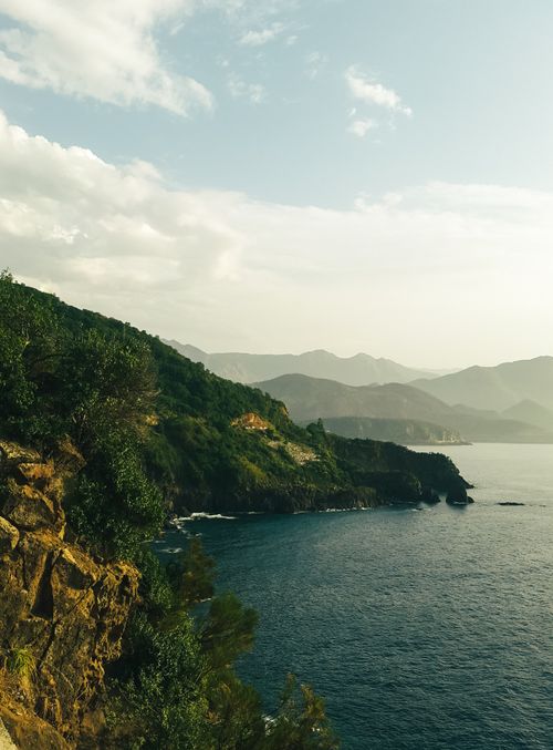 Free A breathtaking view of lush coastal cliffs meeting the boundless ocean under a clear sky. Stock Photo