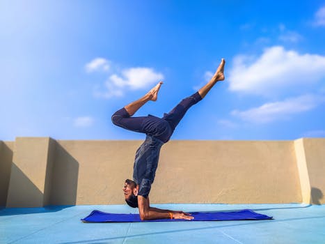 Adult man in yoga pose on rooftop with a bright blue sky background. Ideal for fitness content.