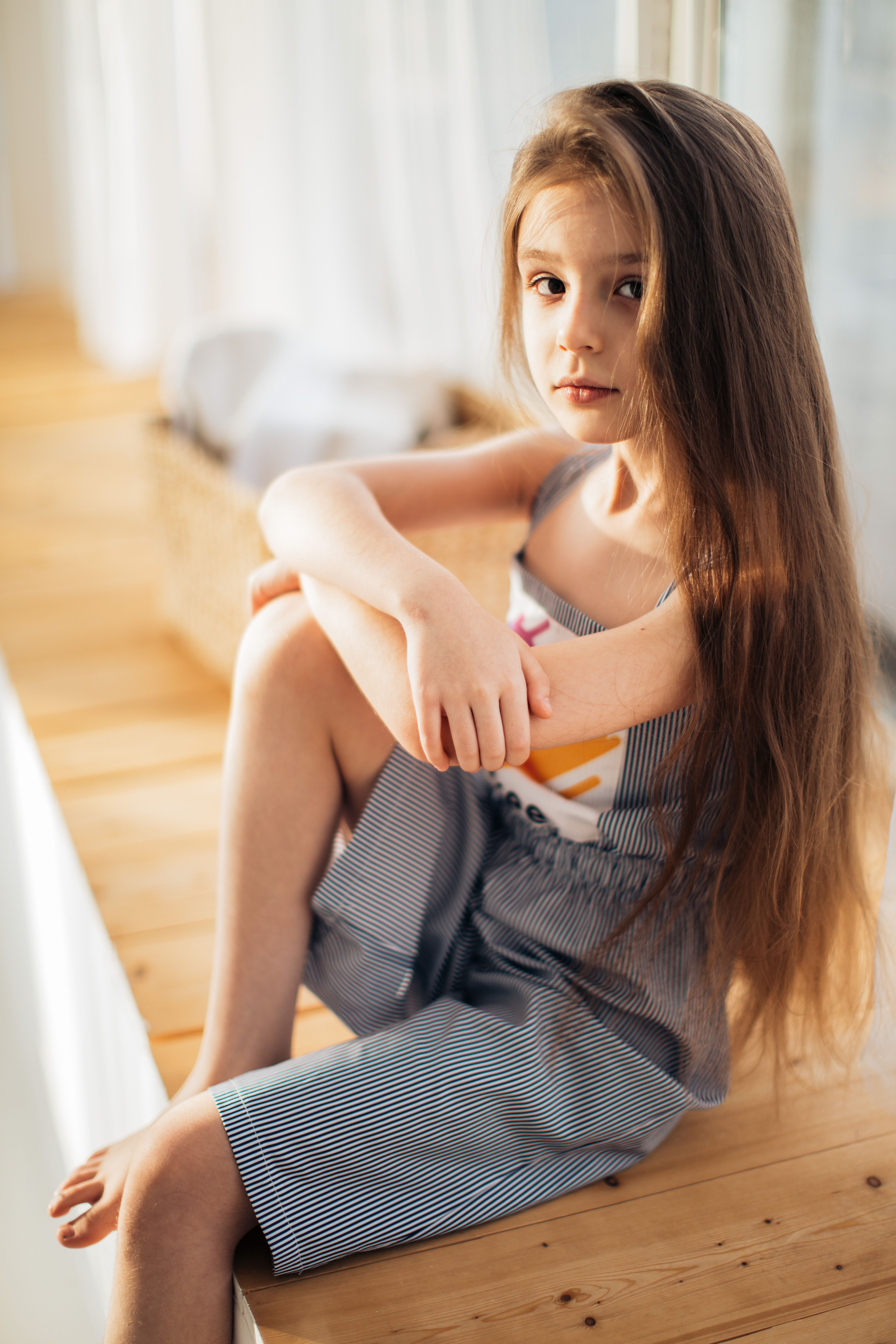 Girl With Long Hair Sitting and Looking at the Camera · Free Stock Photo