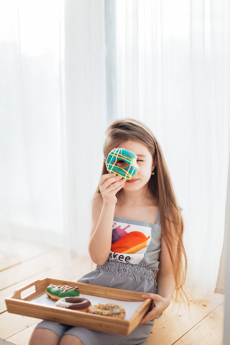 Photo Of A Kid Looking Through A Donut Hole