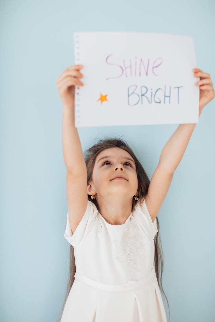 Photo Of A Kid Holding A Piece Of Paper With Text