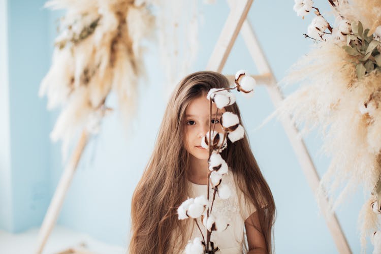 Little Brunette Girl Holding A Cotton Twig 