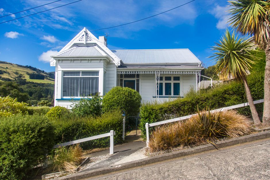 Photo by 飞 谢 on Pexels Quaint white detached cottage on a lush hillside under a vibrant blue sky, featuring lush greenery.