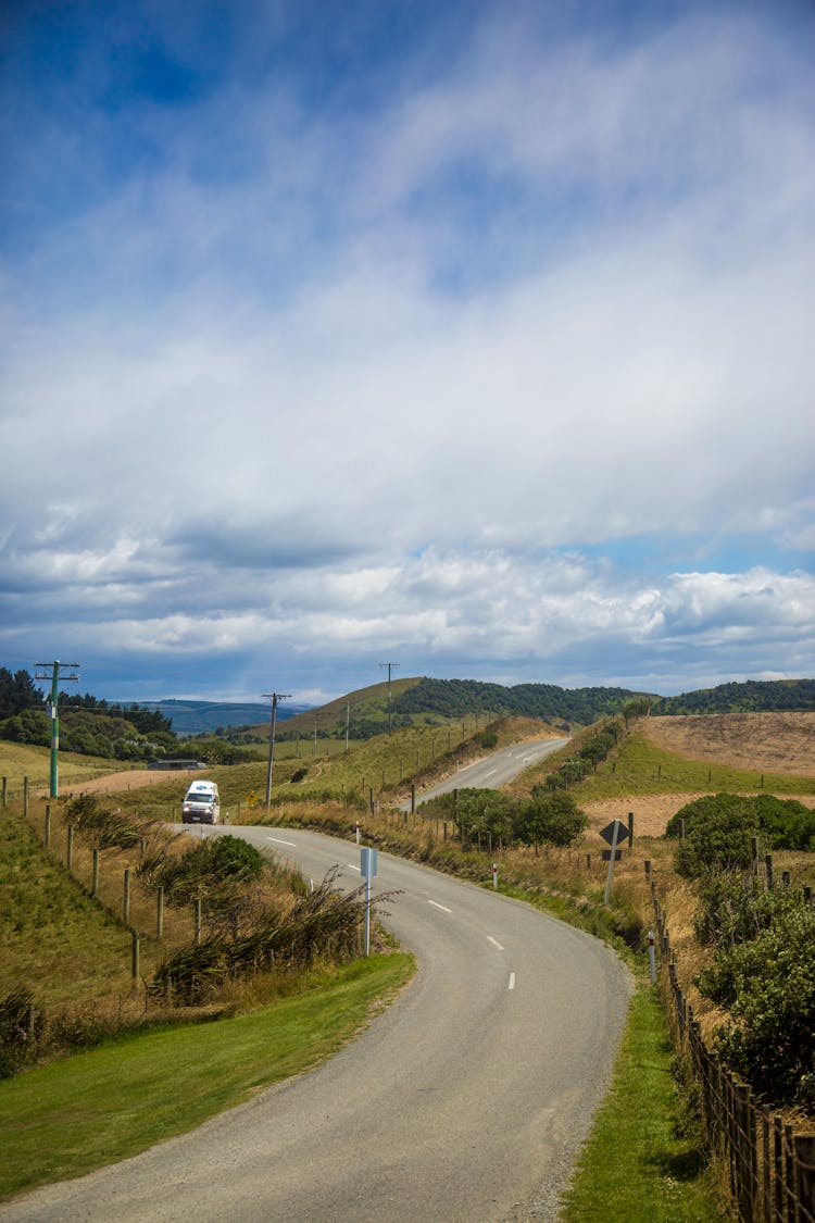 Car Driving On An Asphalt Country Road Between Hills