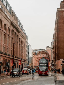 A lively street scene in London featuring architecture and a red double-decker bus.