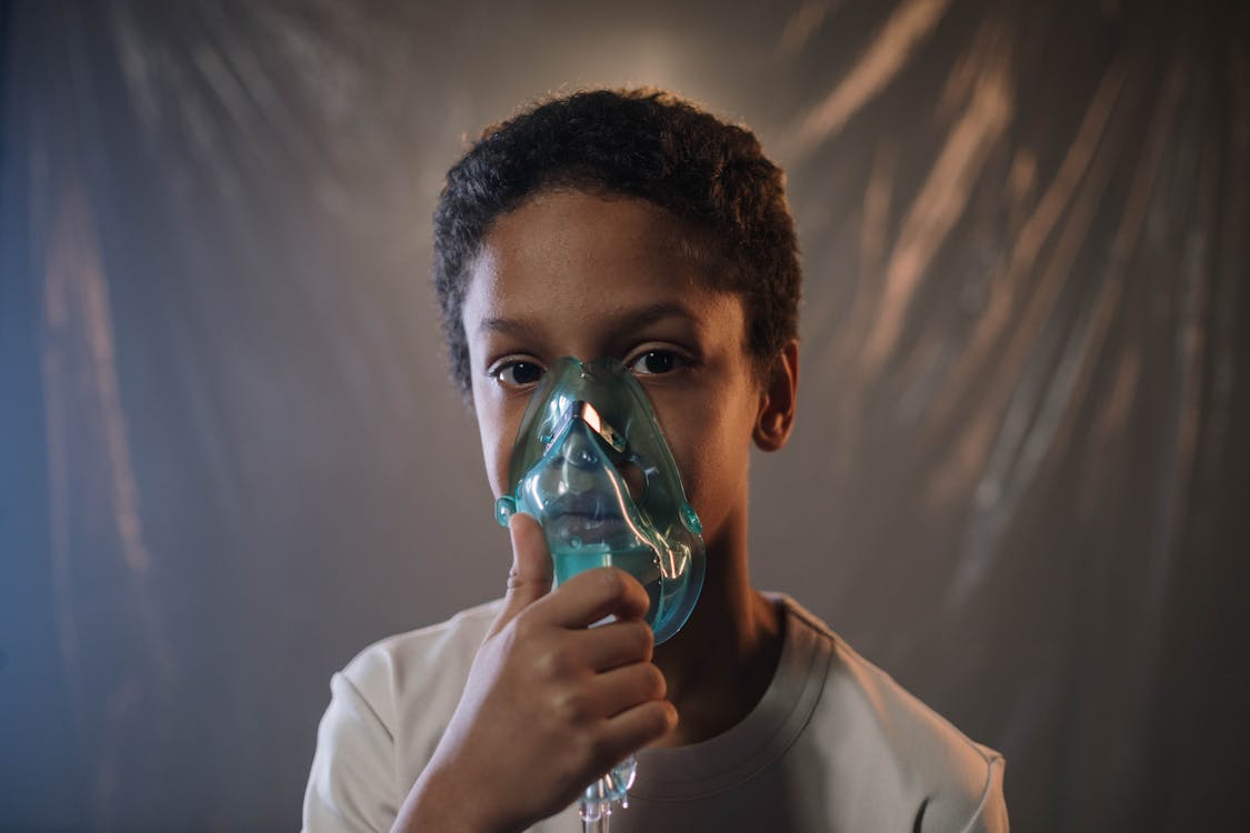 Free A Boy in White Shirt Holding Green Oxygen Mask Stock Photo