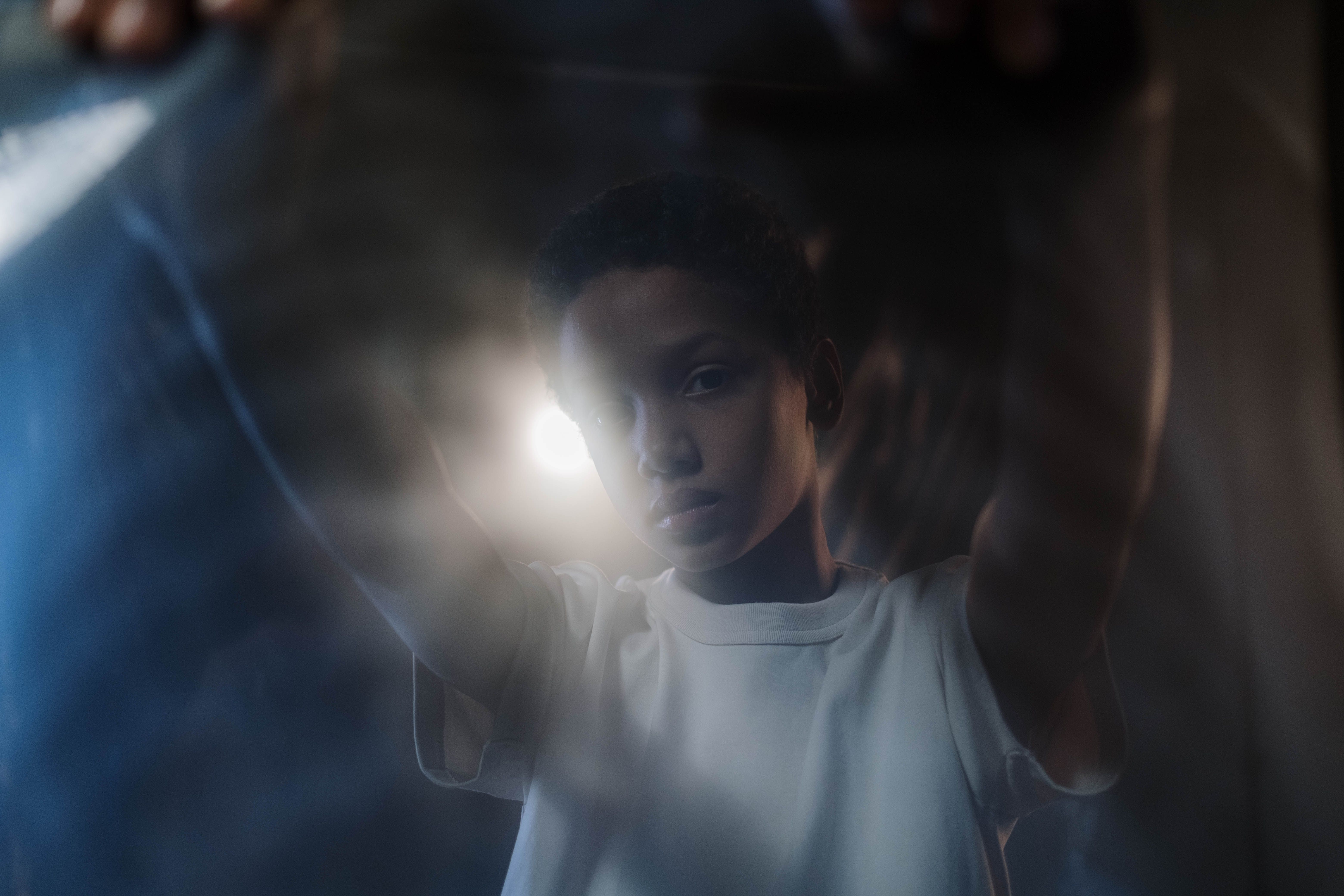 Artistic portrait of a young boy with soft lighting and a moody atmosphere, showcasing creativity.