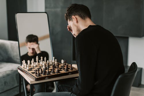 Man in Black Long Sleeve Shirt Playing Chess