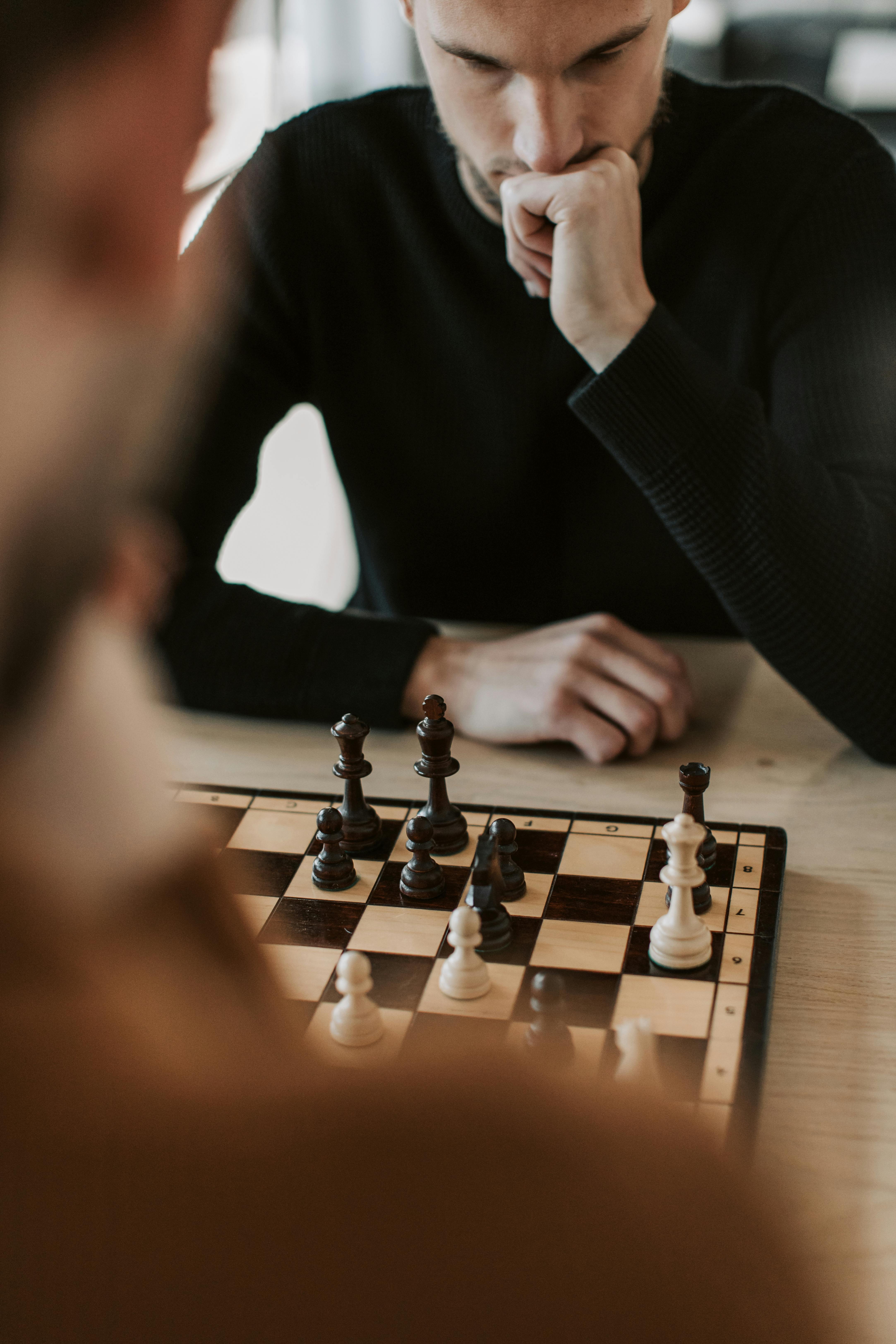 man in black jacket playing chess