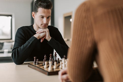 A Man in a Sweatshirt Playing Chess 